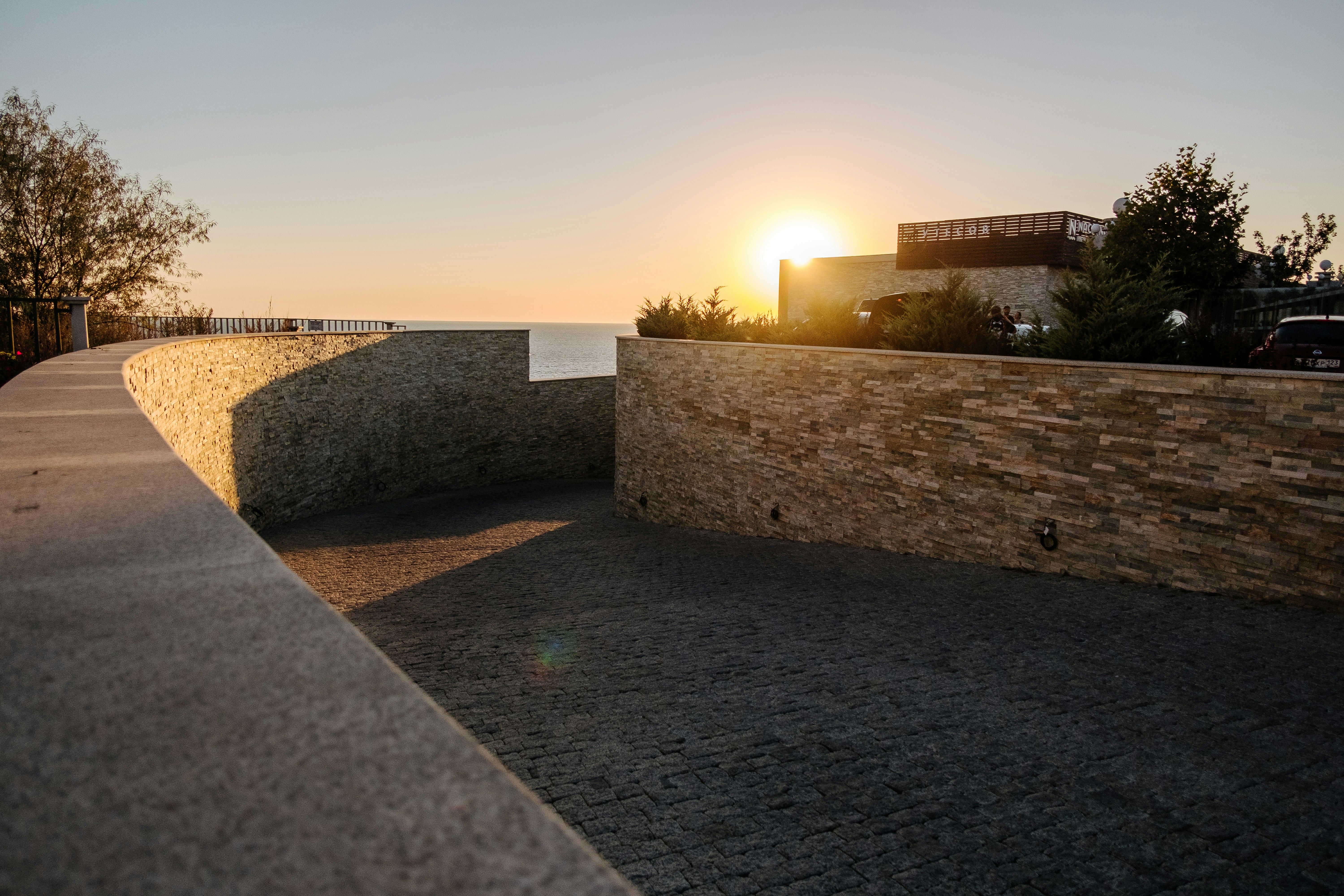 gray concrete wall near green grass during sunset