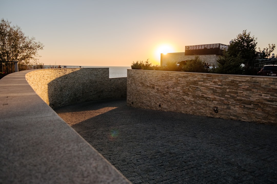 gray concrete wall near green grass during sunset