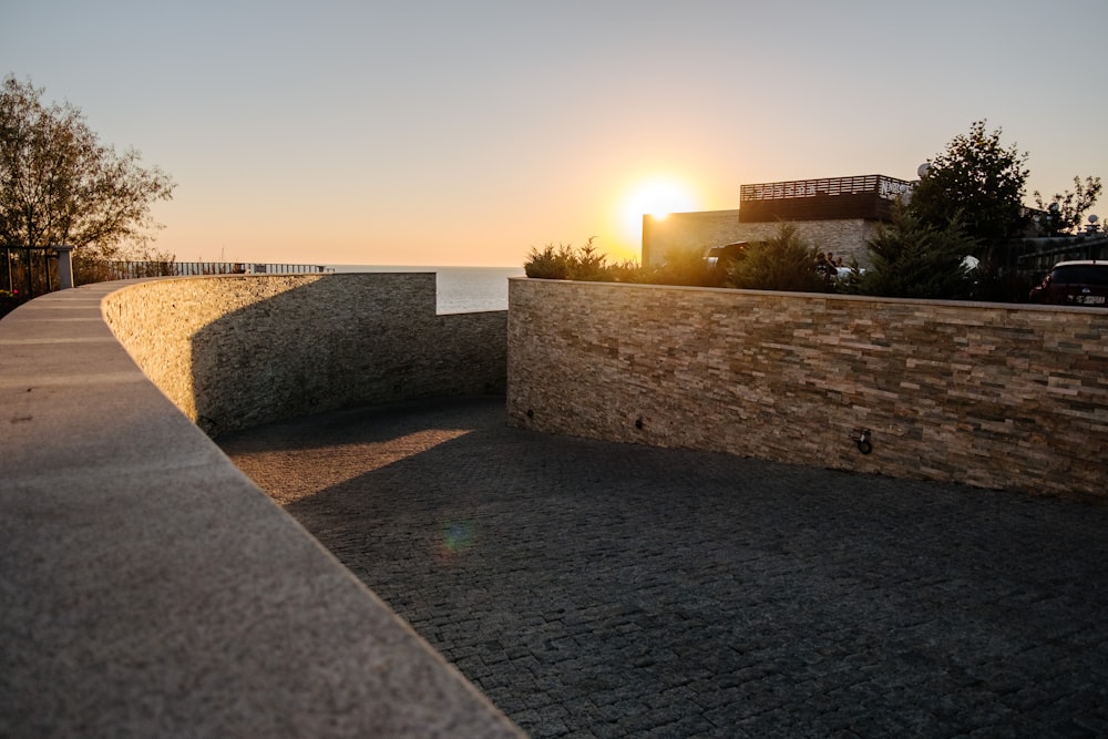 gray concrete wall near green grass during sunset