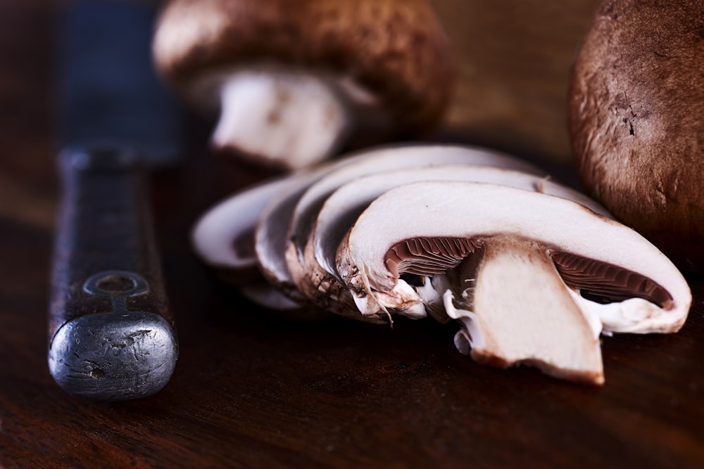 white and brown mushroom on brown wooden table