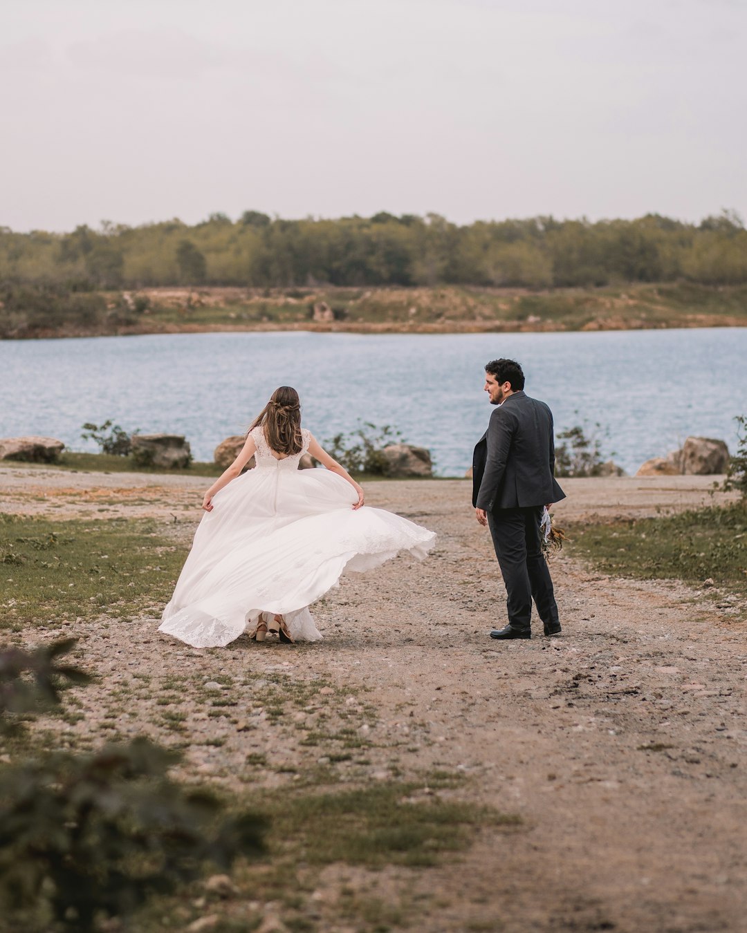 woman in white wedding gown standing beside man in black suit