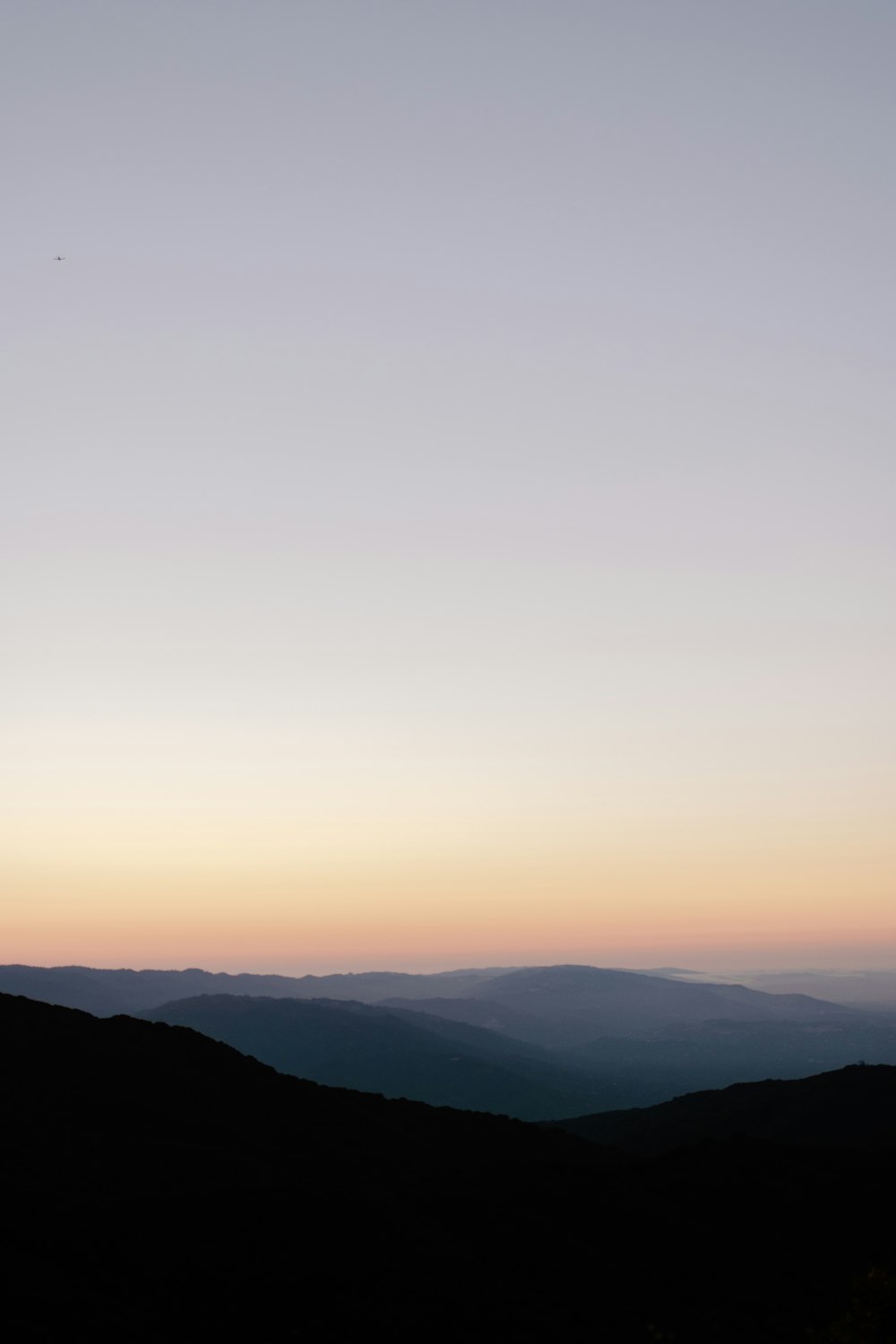 a person standing on top of a mountain at sunset