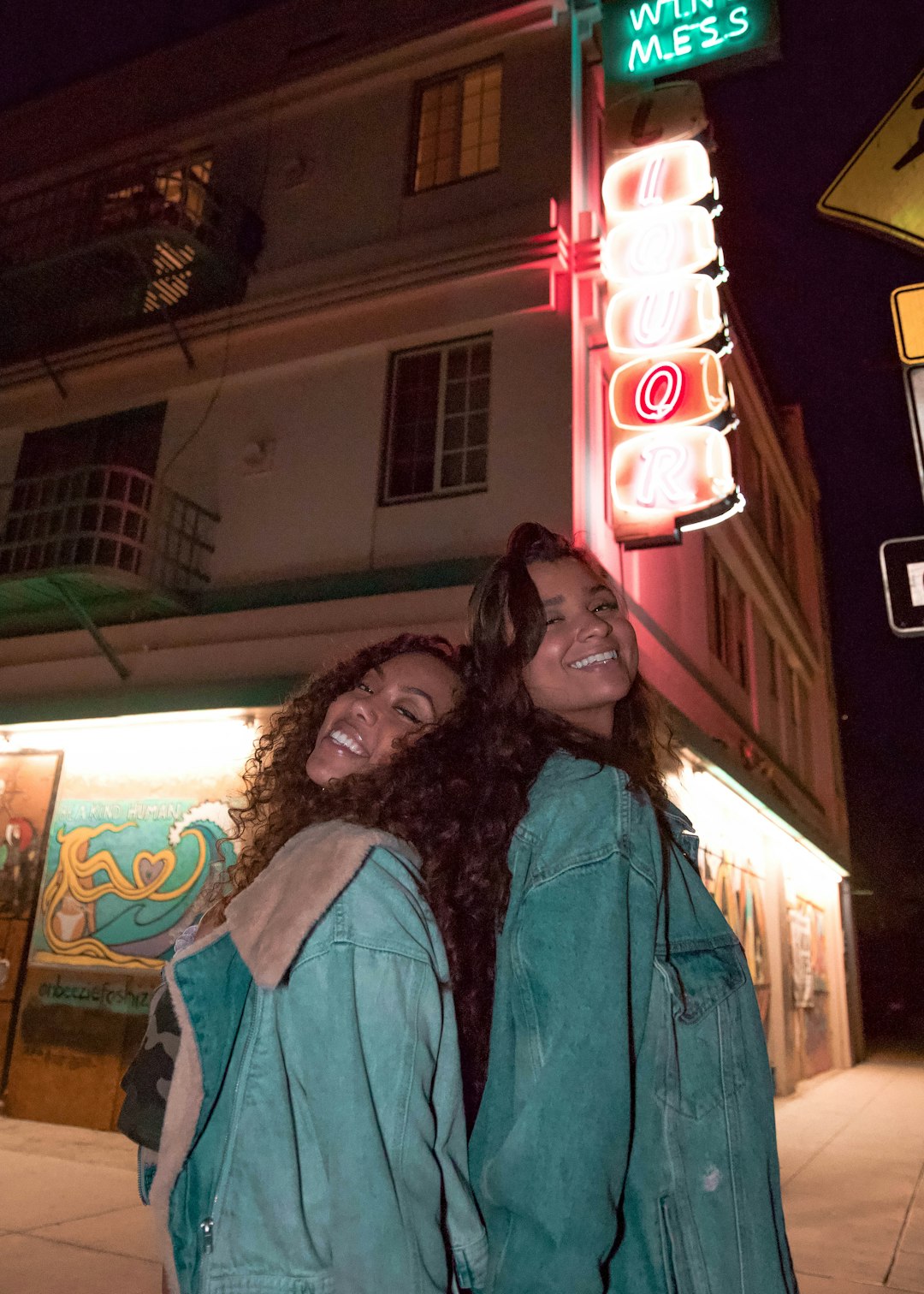 woman in blue denim jacket standing beside woman in black jacket