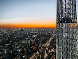 Dynamic cityscape at dusk lit by mobile network towers and signal icons.