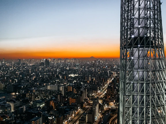 Dynamic cityscape at dusk lit by mobile network towers and signal icons.