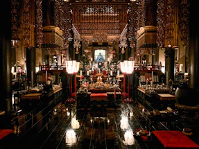 A serene temple interior with candles and prayer offerings.