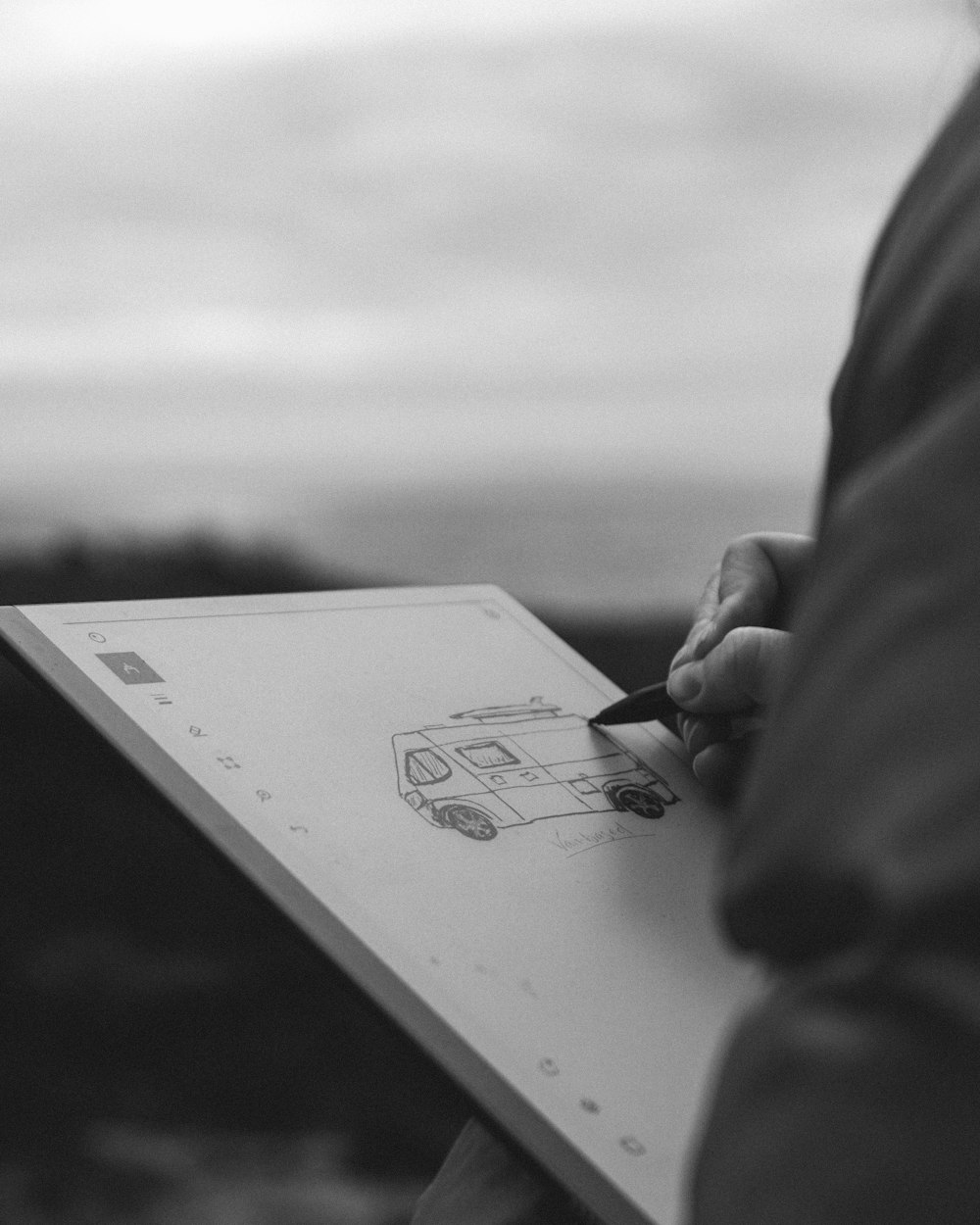 Photo en niveaux de gris d’une personne tenant un stylo écrivant sur du papier blanc