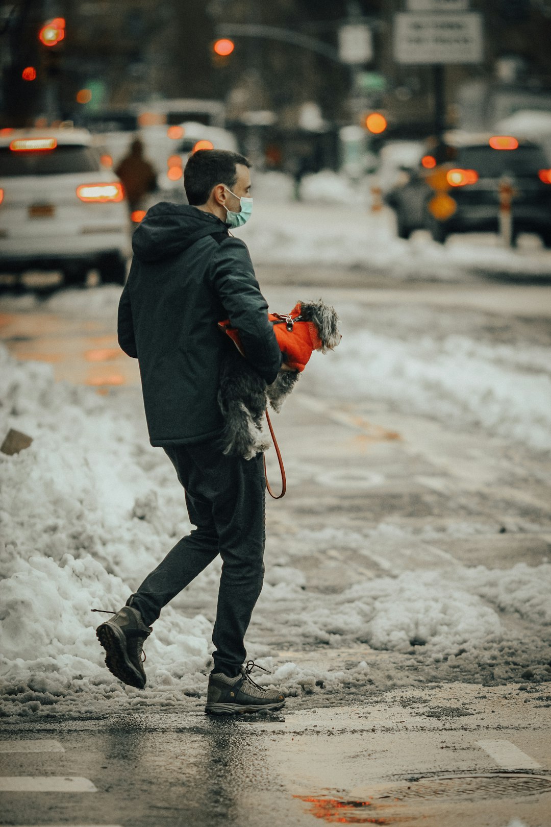 man in black jacket and black pants walking on snow covered ground during daytime