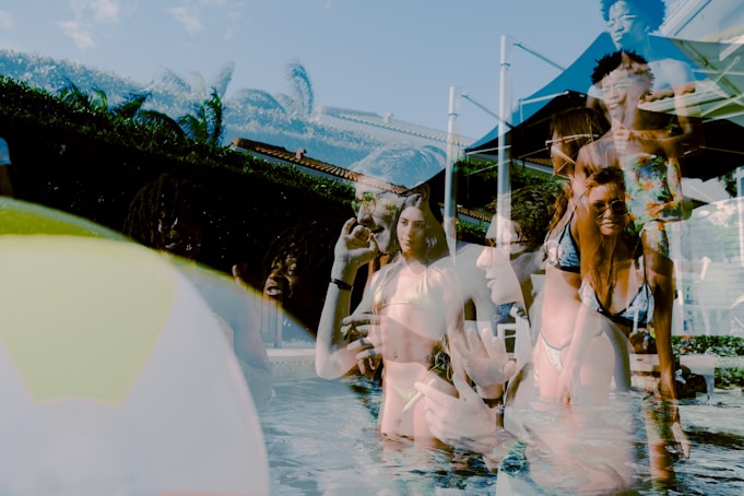 woman in white dress shirt and black sunglasses standing beside water fountain during daytime