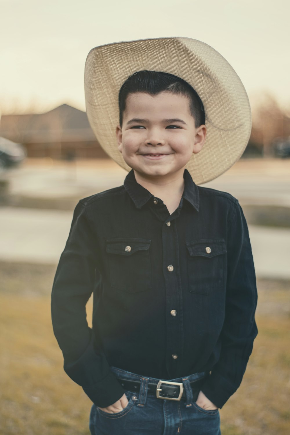boy in black button up long sleeve shirt wearing brown straw hat