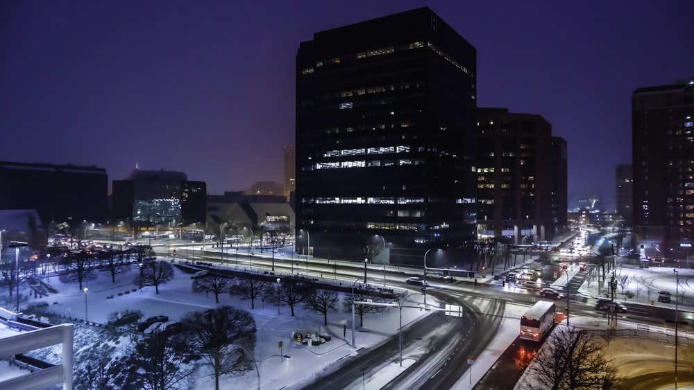 cars on road near high rise buildings during night time