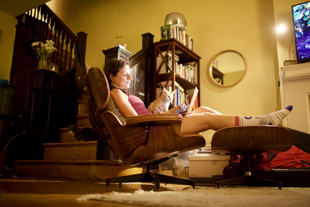 woman in white shirt sitting on brown wooden armchair