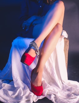 woman in blue dress lying on white bed