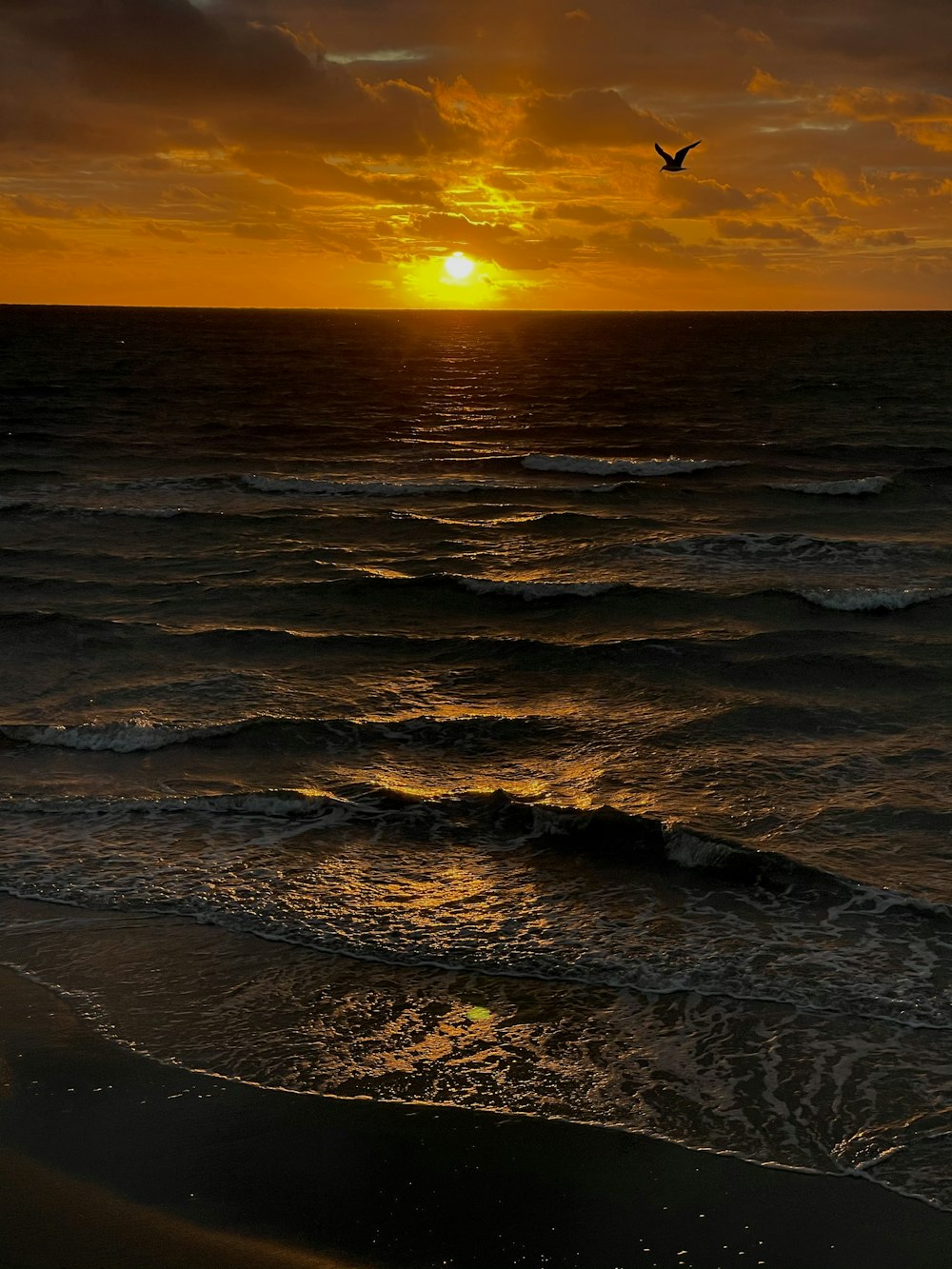 ocean waves crashing on shore during sunset