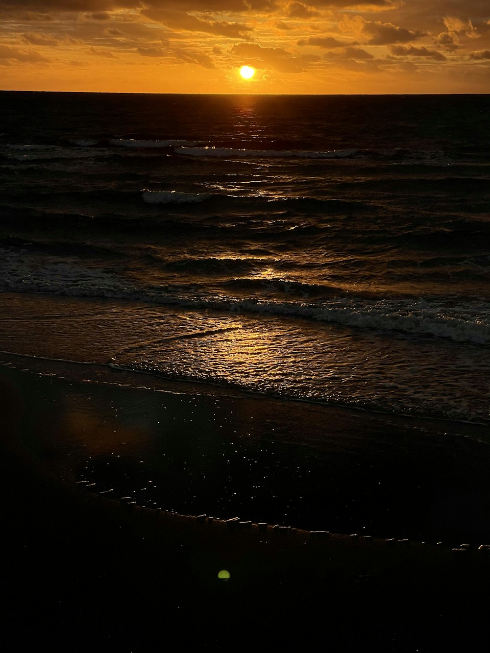 sea waves crashing on shore during sunset