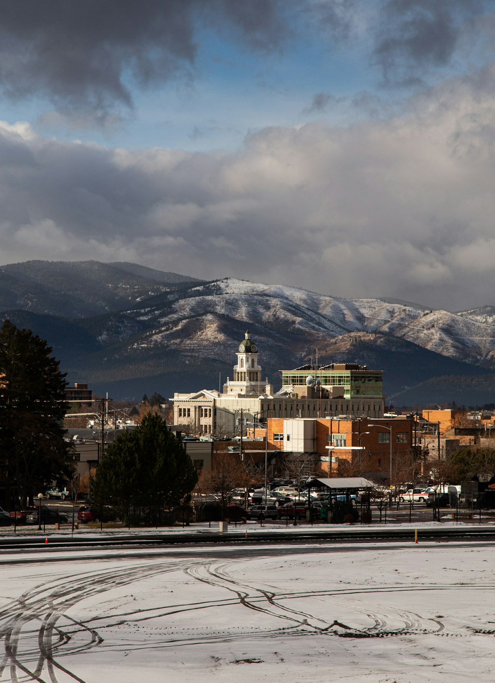 white and brown concrete building near mountain under white clouds during daytime