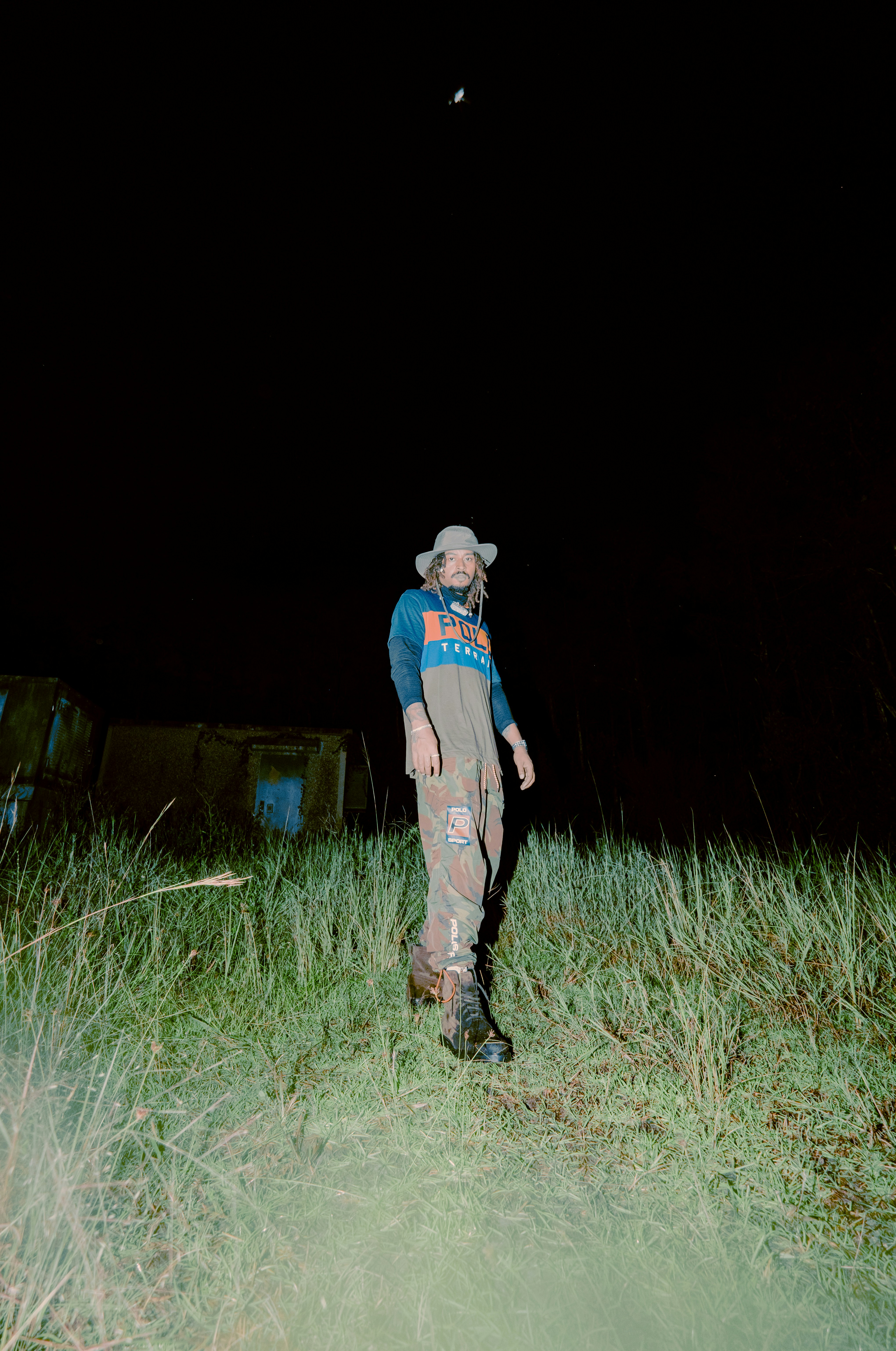 man in blue and white plaid dress shirt and brown pants standing on green grass field