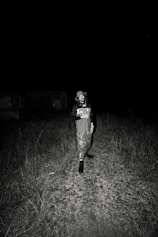woman in black and white t-shirt and black pants standing on green grass field during