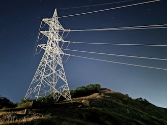 Electricity transmission tower and lines lit at night