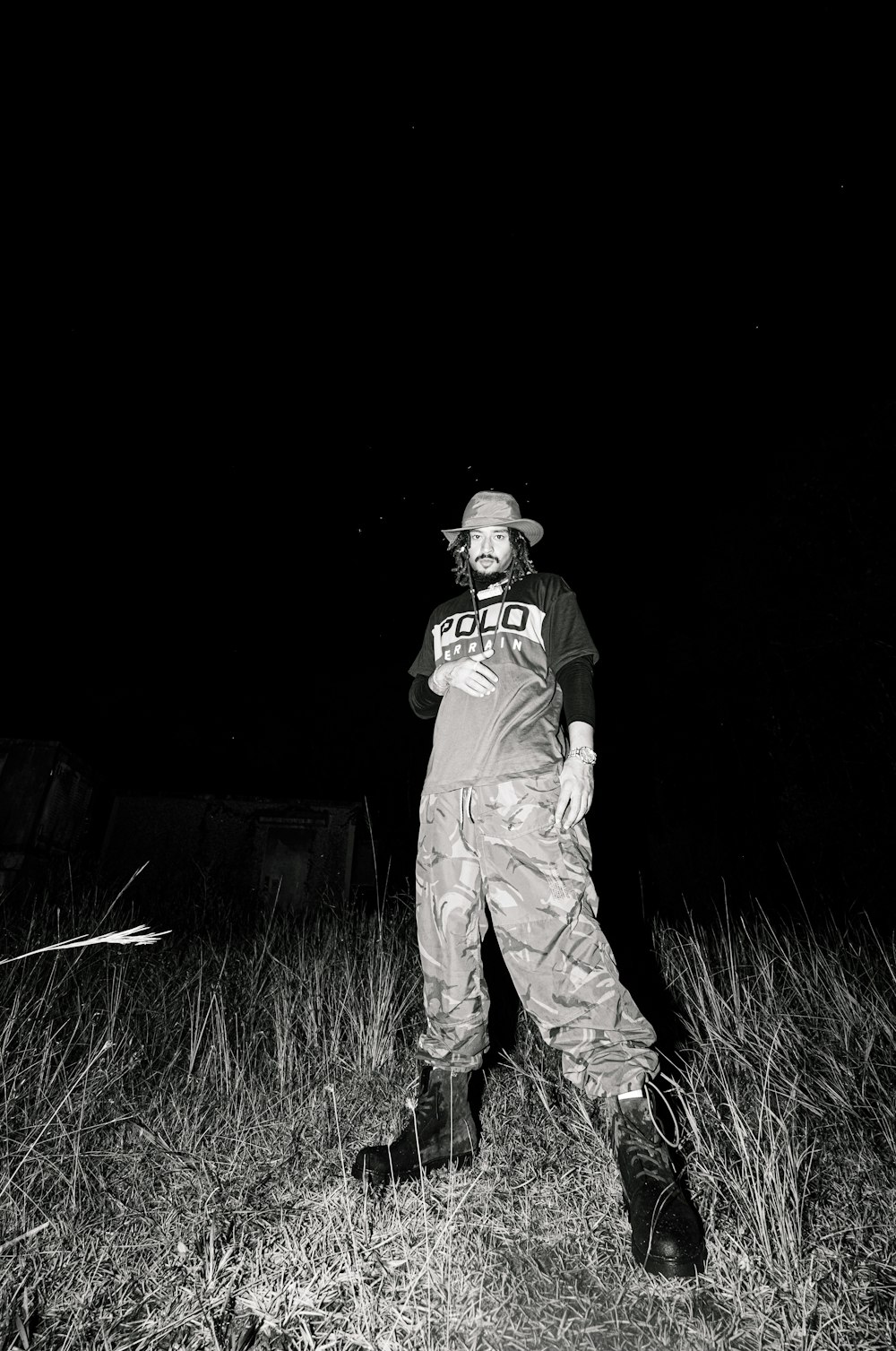 man in brown pants and black jacket standing on green grass field during nighttime