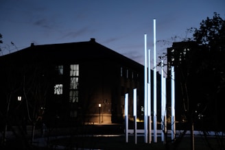 Technicians installing LED modules on a towering outdoor video wall at dusk.