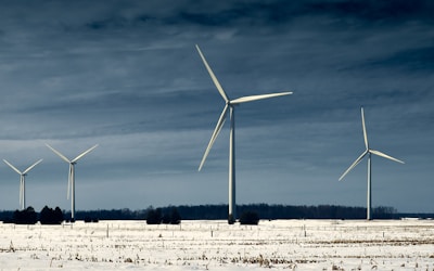 white wind turbines on field under blue sky during daytime
