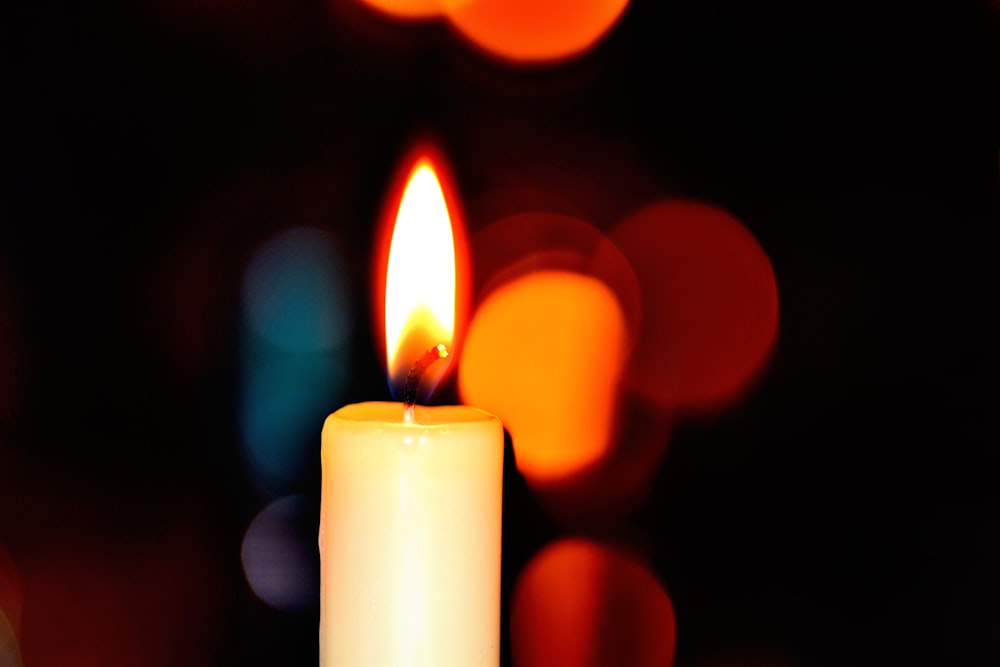 white candle in bokeh photography