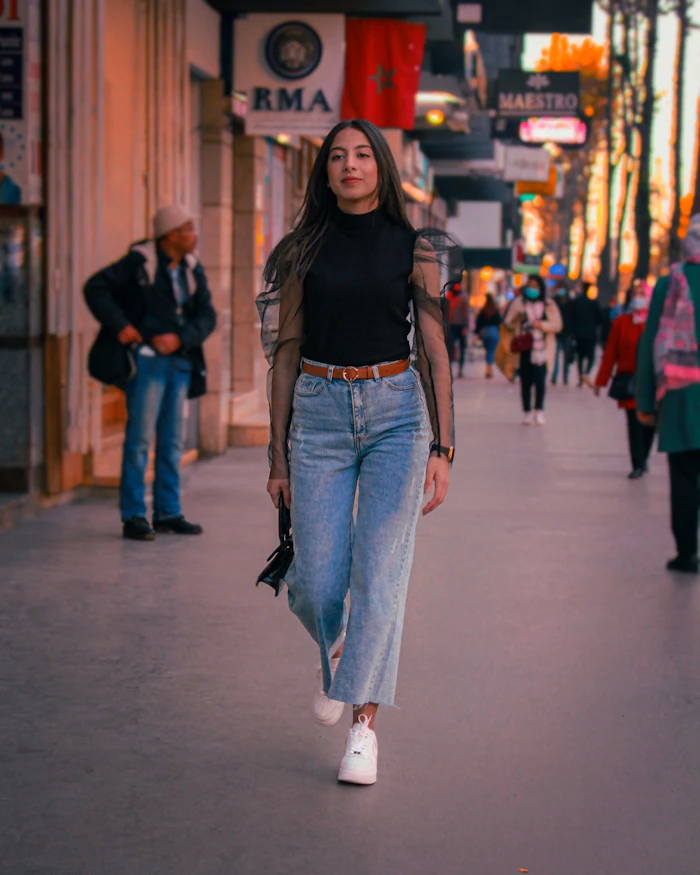 Woman in a black shirt and blue jeans on a city street