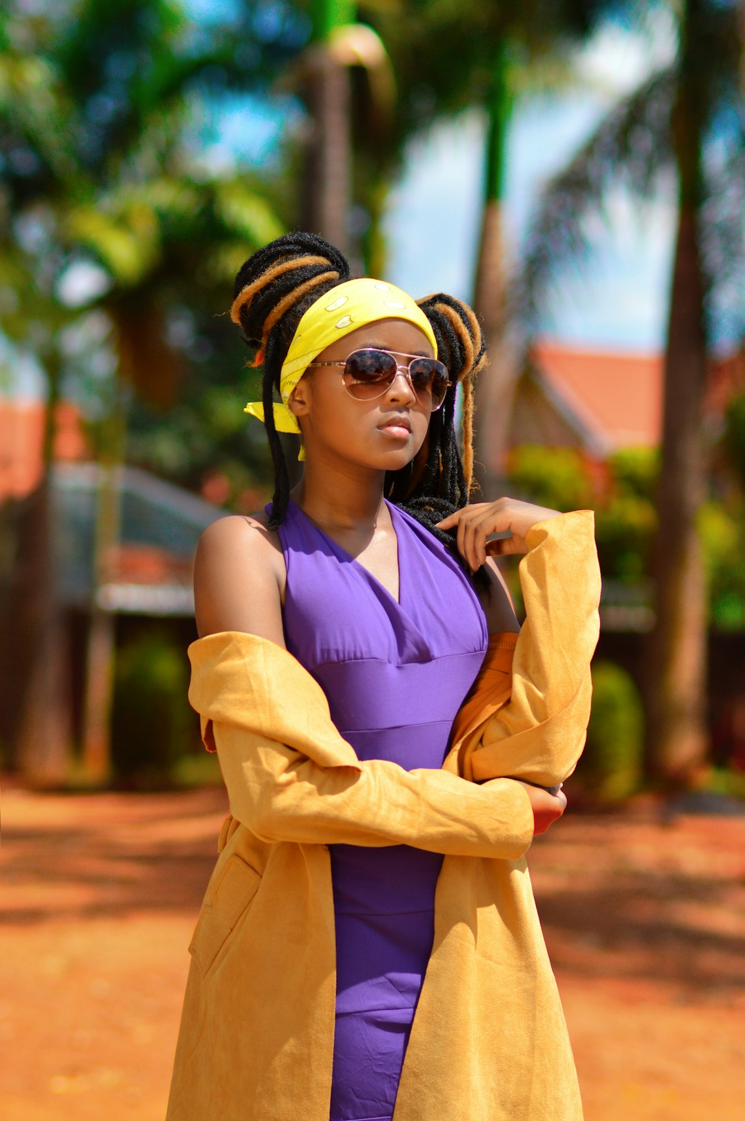 woman in purple tank top and brown coat wearing yellow sunglasses