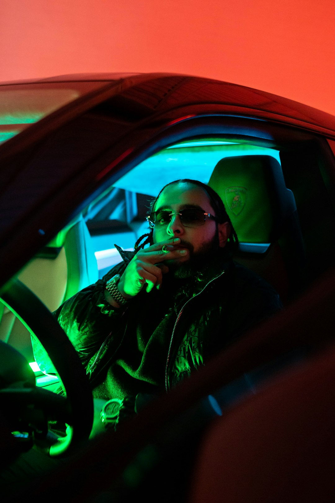 man in black jacket wearing sunglasses sitting inside car