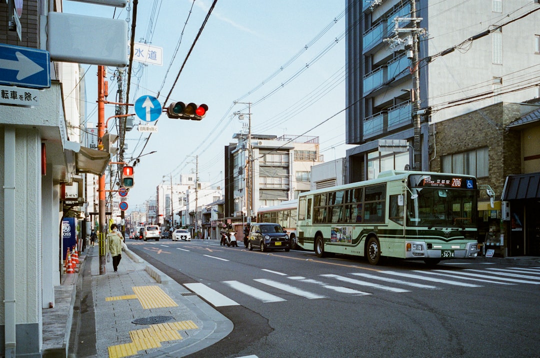 green bus on road during daytime