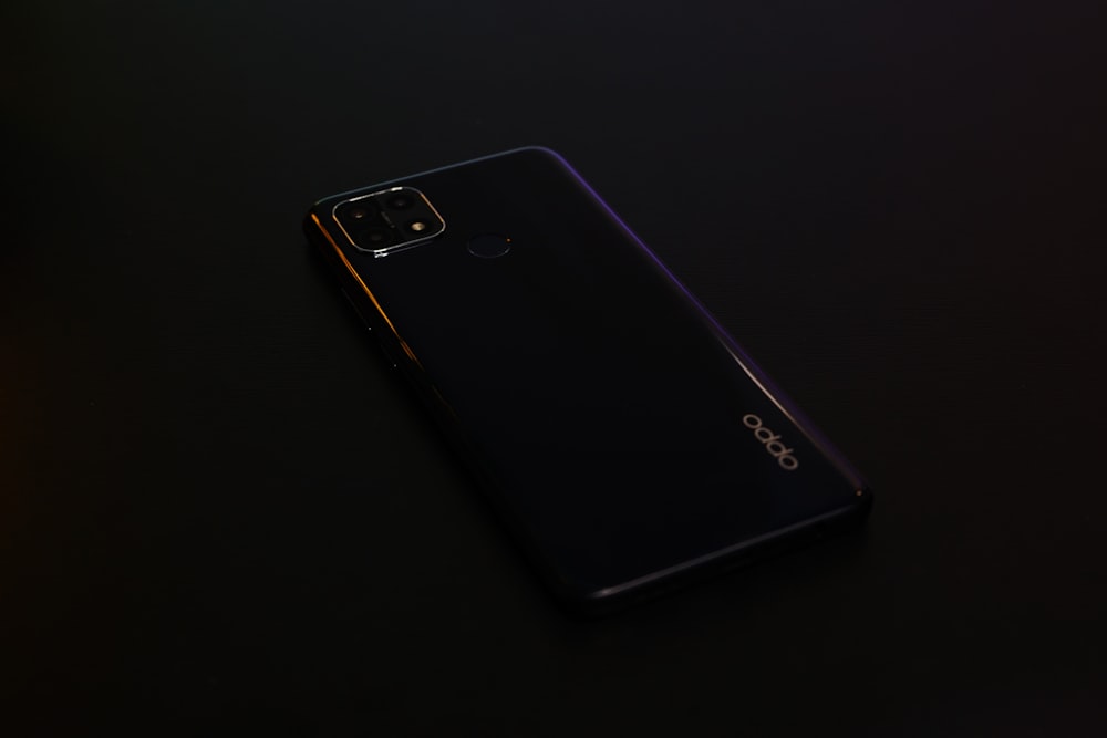Schwarzes Samsung Android Smartphone auf schwarzer Oberfläche