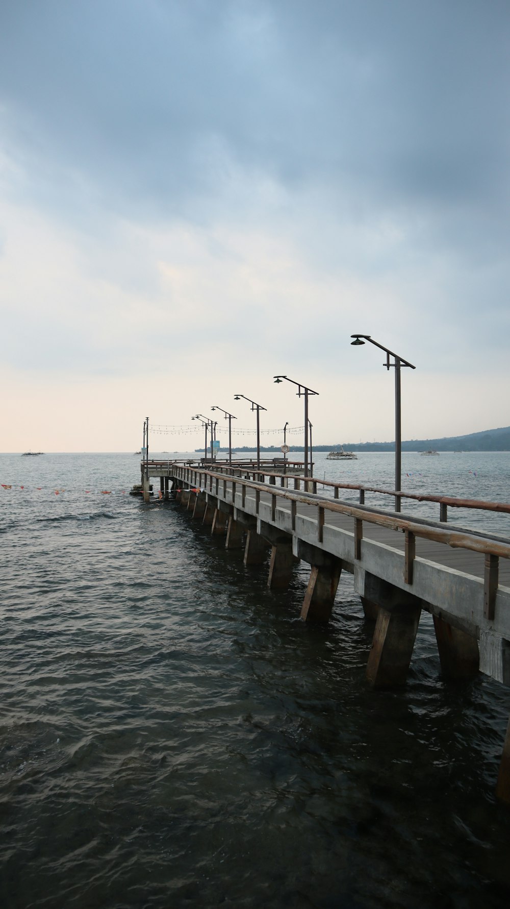 brown wooden dock on sea under white sky during daytime