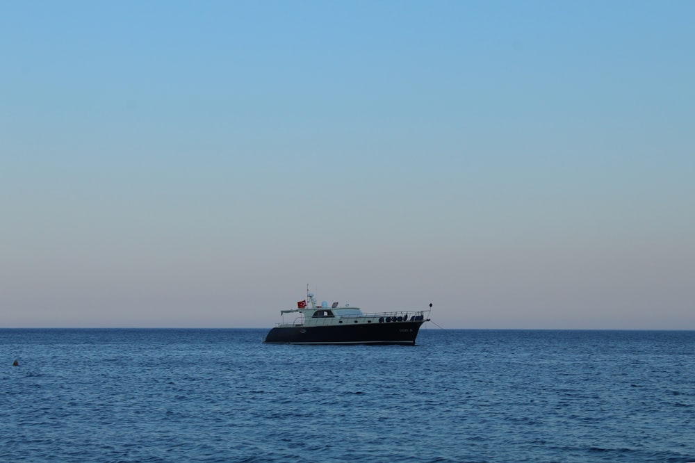 black and white ship on sea under blue sky during daytime