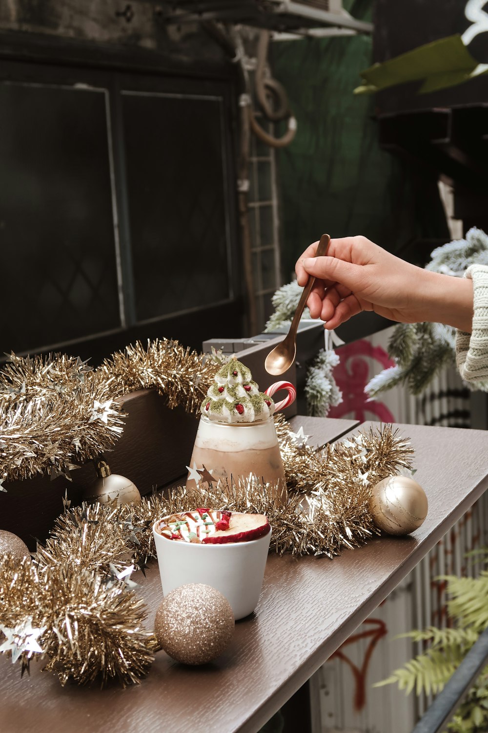 person holding silver spoon with white ceramic mug