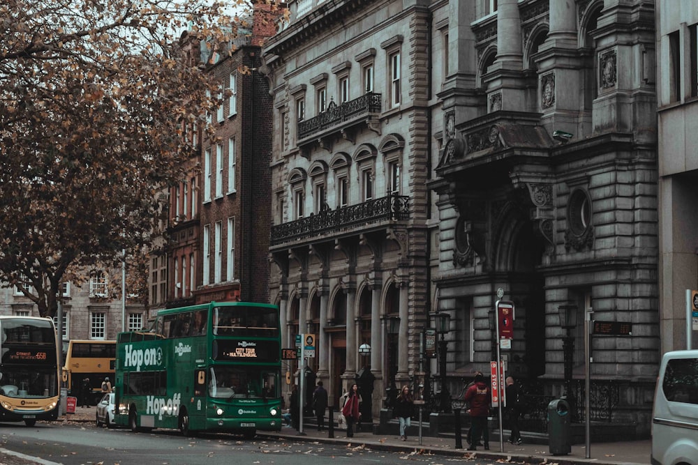 green bus on road near building during daytime