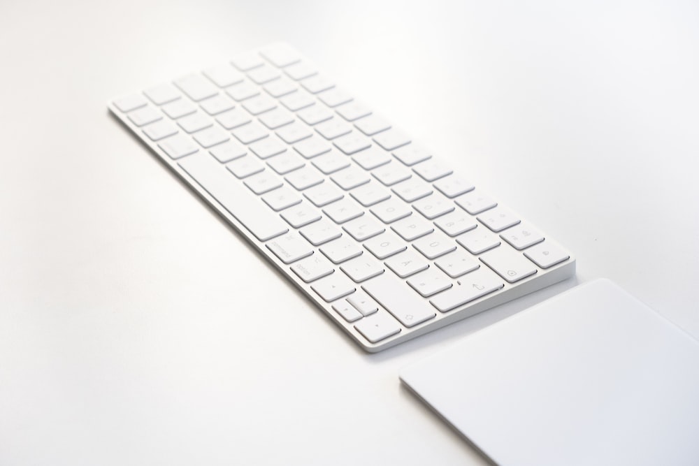 白いテーブルの上の白いアップルキーボード