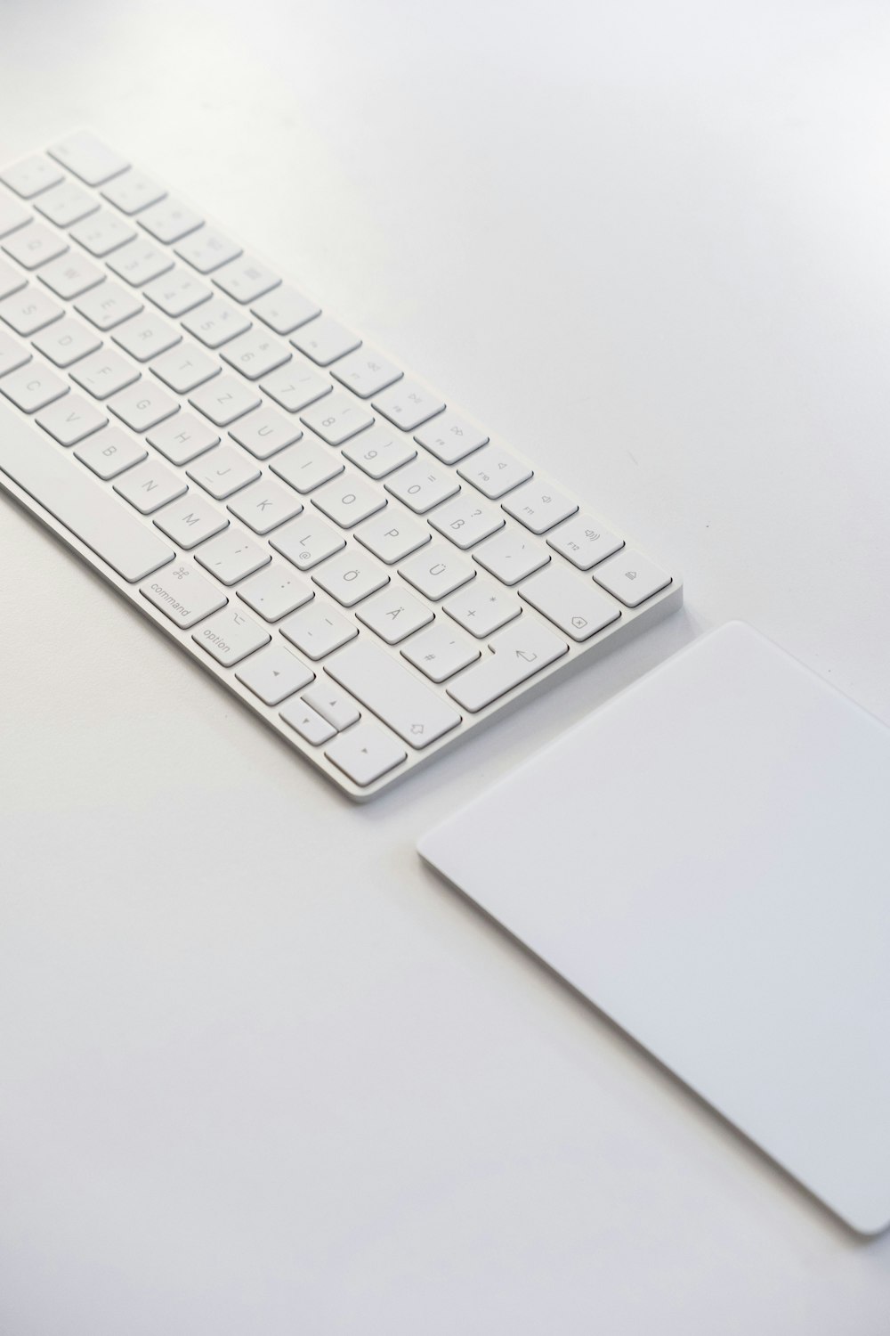 Teclado blanco de Apple sobre mesa blanca