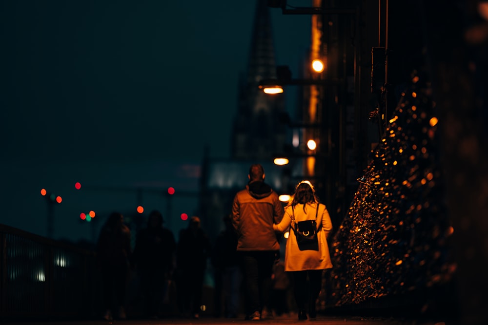 man in yellow jacket standing beside woman in yellow coat during night time