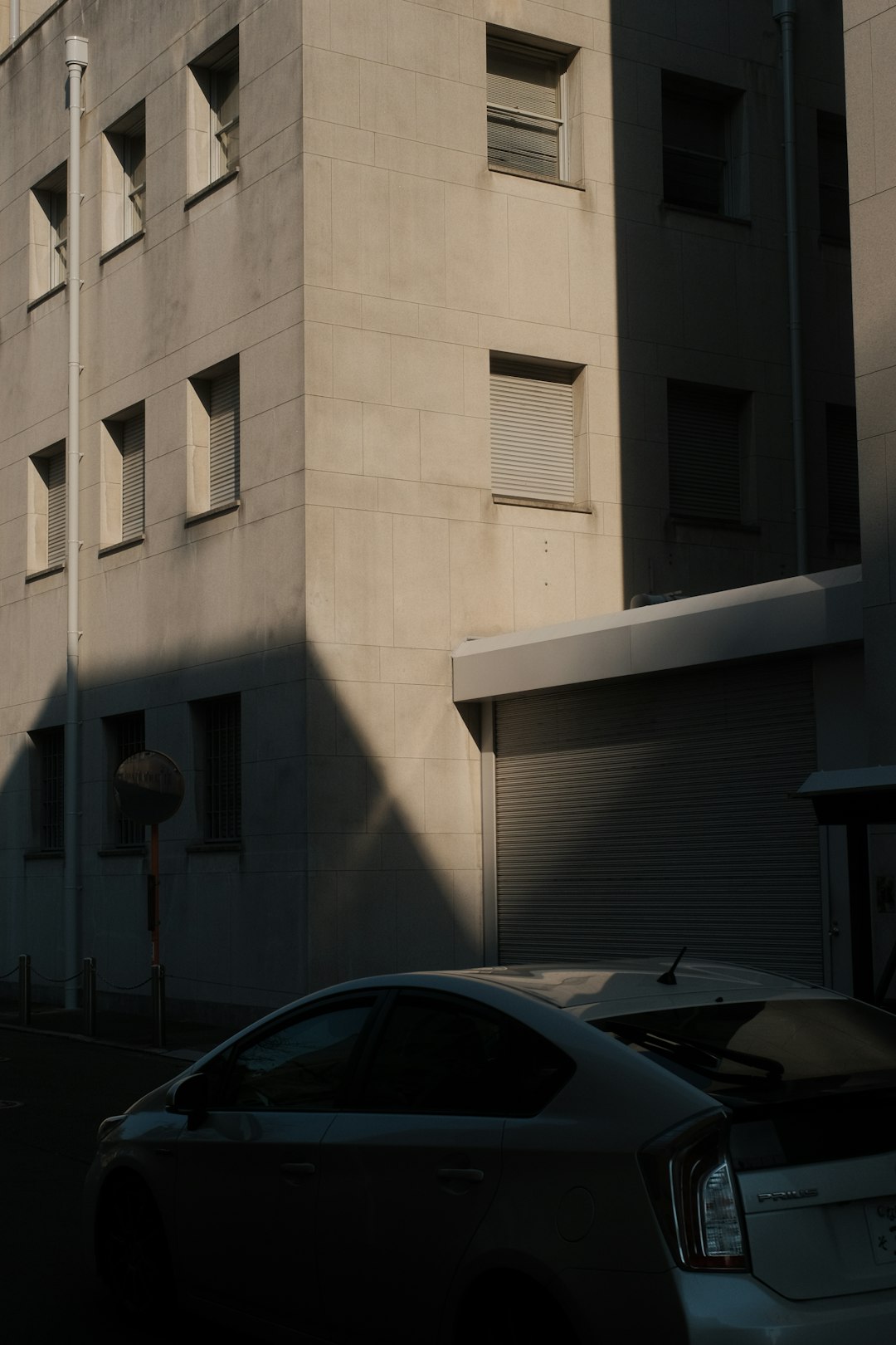 black car parked beside white building