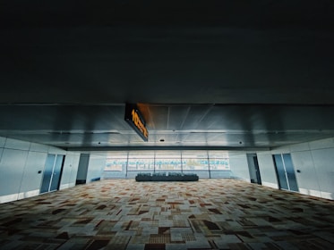 A spacious hospital corridor with professionally installed raised flooring and carpet tiles.