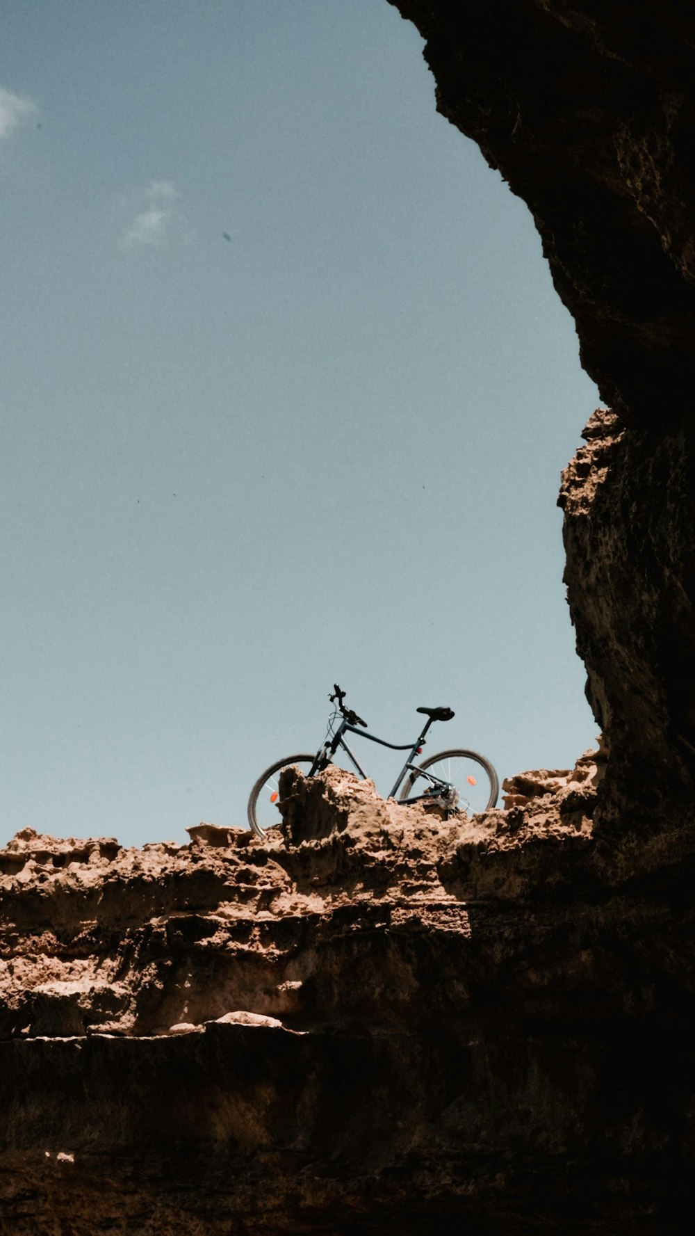 black mountain bike on brown rock formation during daytime