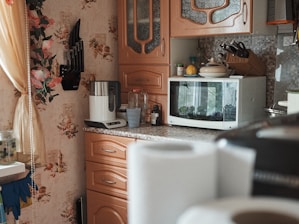 white microwave oven on brown wooden cabinet