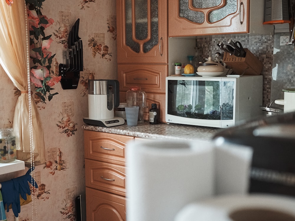 Horno microondas blanco sobre mueble de madera marrón