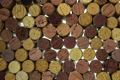 Close-up of wine cork crafts arranged on a weathered wooden table.