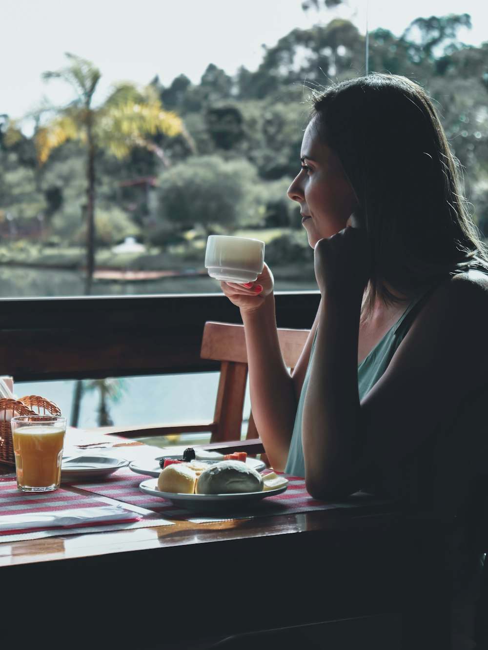 woman in black tank top sitting on chair holding drinking glass