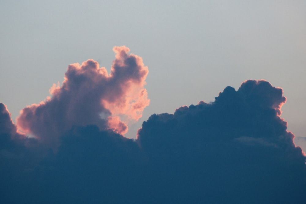 white clouds over silhouette of mountain