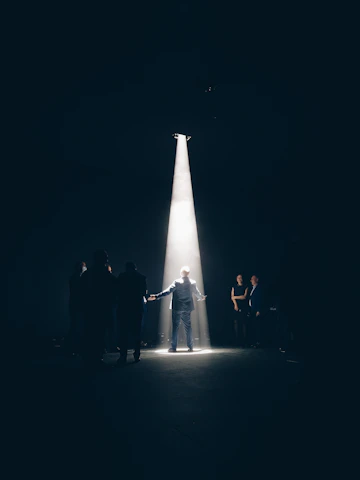 Stephen passionately acting on stage, spotlight highlighting his focused expression.