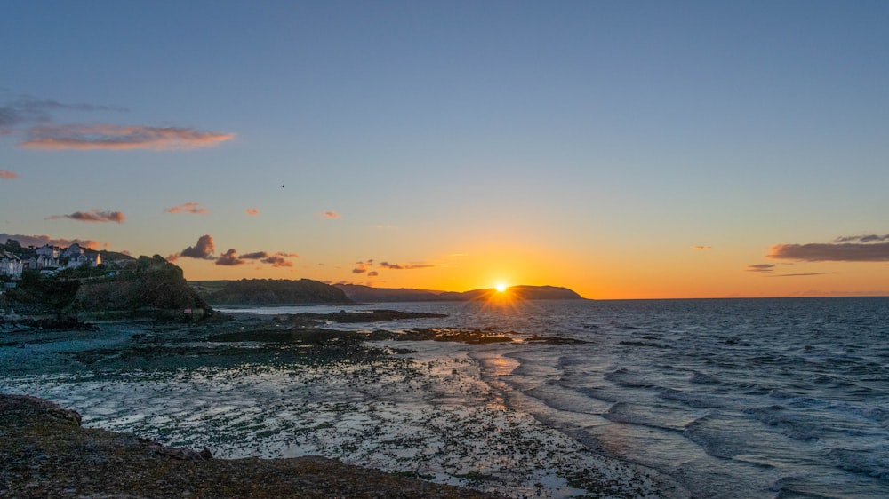 sea waves crashing on shore during sunset