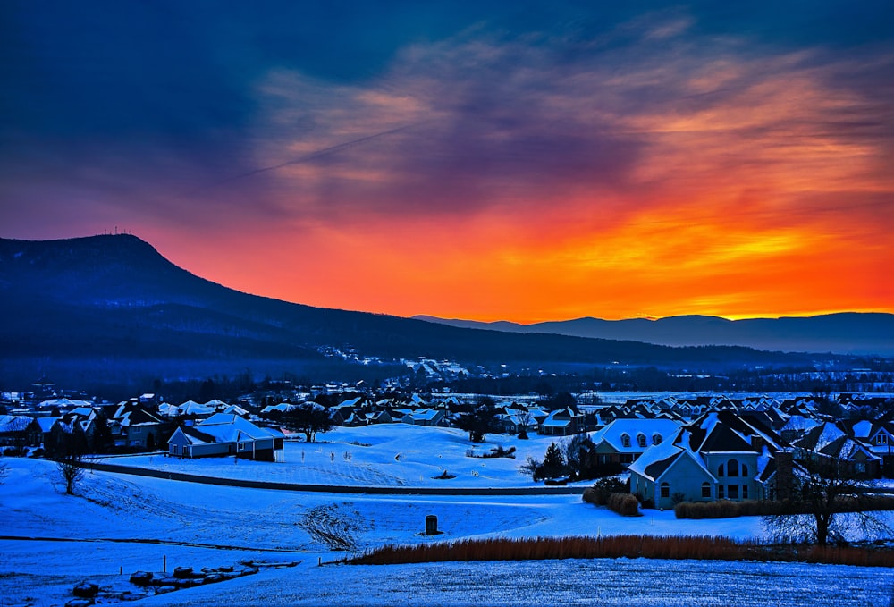 Häuser auf schneebedecktem Boden bei Sonnenuntergang